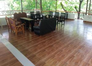 a large room with chairs and tables and wooden floors at 4M FarmStay in Bodināyakkanūr