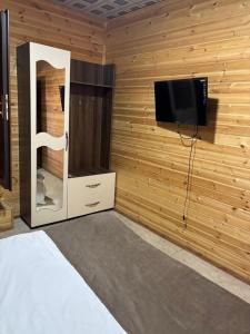 a room with a flat screen tv and a bed at Vələs Garden in Quba +111 photos