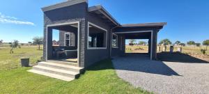a small house with a porch and stairs in a field at Waterfront Cottage 121 in Grooteiland