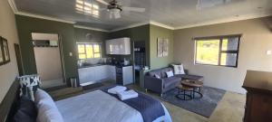 a bedroom with a bed and a couch and a kitchen at Waterfront Cottage 121 in Grooteiland