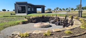 a fire pit in a yard with chairs and a house at Waterfront Cottage 121 in Grooteiland +4 photos