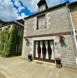 a brick house with a garage with two doors at Maison de Rêve in Notre-Dame-du-Touchet