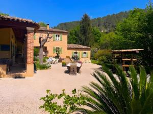 a patio of a house with a table and chairs at Bastidon les Oliviers in Belgentier