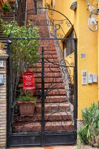 an iron gate with a staircase in front of a building at Taormela 1 - Holiday Apartment in Taormina