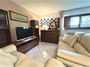 a living room with a couch and a flat screen tv at Villa Maria Grazia in Lucca
