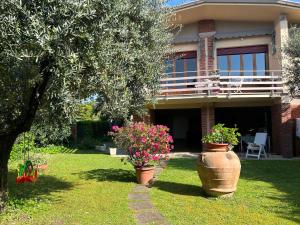 a house with two large pots of flowers in the yard at Villa Maria Grazia in Lucca