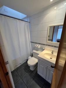 a white bathroom with a toilet and a sink at Hostería Vitacura in Santiago +11 photos