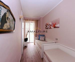 ein Wohnzimmer mit einem Bett und einer Couch in der Unterkunft Casa Serena in Amalfi