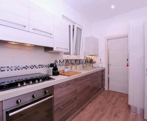 eine Küche mit weißen Schränken und einer Arbeitsplatte in der Unterkunft Casa Serena in Amalfi + 10 Fotos