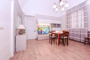 eine Küche und ein Esszimmer mit einem Tisch und einem TV in der Unterkunft Casa Serena in Amalfi