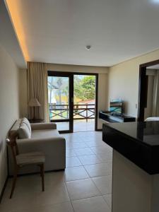 a living room with a bed and a table and a kitchen at Kariri Beach Residence in Caucaia