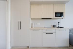 a white kitchen with white cabinets and a sink at S1 Apartamenty Rewa in Rewa