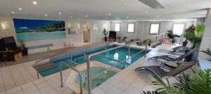 a large swimming pool with chairs in a room at Panorama Hotel Oberwiesenthal im Erzgebirge in Kurort Oberwiesenthal +40 photos