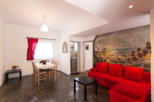 a living room with a red couch and a table at PAROS APARTMENT MELAS α1 in Parikia