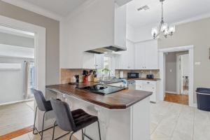 a kitchen with white cabinets and a wooden counter top at Downtown Cottage in Lake Charles