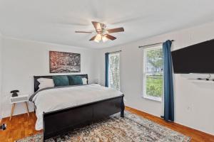 a bedroom with a bed and a ceiling fan at Downtown Cottage in Lake Charles +5 photos