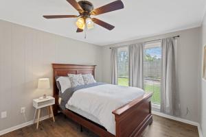 a bedroom with a bed with a ceiling fan at Downtown Cottage in Lake Charles