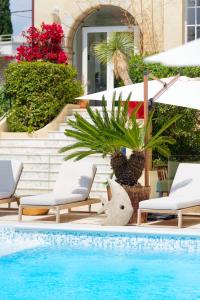 a swimming pool with chairs and umbrellas next to at La Garoupe-Gardiole in Antibes +31 photos