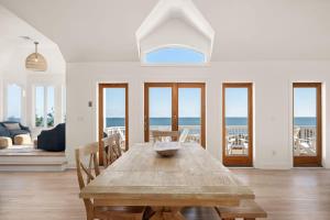 a wooden table in a living room with a view of the ocean at Beachfront Bliss with Pool & Hot Tub in Corolla