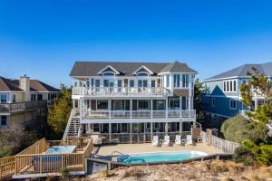 a large white house with a swimming pool and a house at Beachfront Bliss with Pool & Hot Tub in Corolla +48 photos