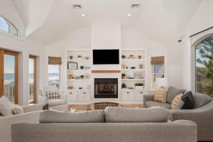 a living room with two couches and a fireplace at Beachfront Bliss with Pool & Hot Tub in Corolla