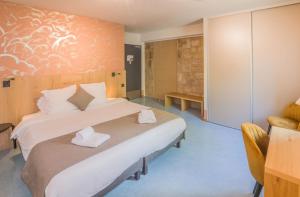 Postel nebo postele na pokoji v ubytování L'HÔTEL DES BAINS - Salles-la-Source