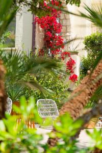 two white chairs in a garden with red flowers at La Garoupe-Gardiole in Antibes