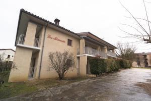 a building with a sign on the side of it at Les Mimosas - App 06 - Appartement Cosy RDC in Cazaubon