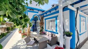 a blue and white building with a bench and plants at Complex Turistic Casa Anastasia in Murighiol