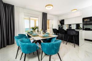 a dining room with a table and blue chairs at Villa Adria Maria 2 in Privlaka