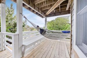 a hammock on the porch of a house at Ocean Views Pool Hot Tub & 7Min Walk to Beach in Corolla