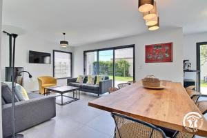 キブロンにあるLa maison de kervozesの木製のテーブルと椅子のあるリビングルーム