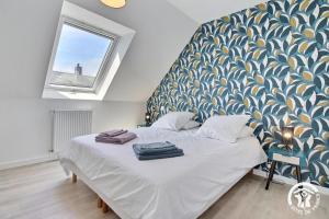 キブロンにあるLa maison de kervozesのベッドルーム1室(青と白のパターンの壁のベッド1台付)