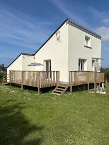 une maison blanche avec une véranda et une terrasse dans l'établissement Haut de l'issue, à Ploubazlanec