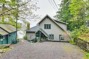 a white house with a garage and a driveway at Lakefront Adirondacks Home Lake George Oasis! in Huletts Landing
