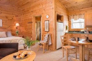 a bedroom and kitchen in a log cabin at Sterling Ridge Resort in Jeffersonville