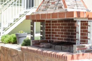a brick fireplace with a grill on a wall at Annis House in Epanomi