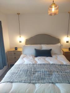 a bedroom with a large white bed with two pillows at The Mason's Arms Fellside rooms in Long Marton