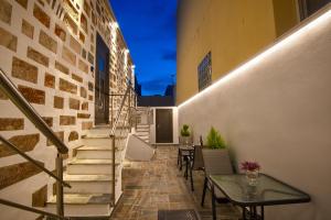 a balcony with stairs and a table and chairs at Elements Syros Apartments in Ermoupoli