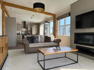 a living room with a couch and a table at Luxury Lodge Retreat with Hot Tub - Stewarts Resort 19 in St. Andrews