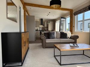 a living room with a couch and a table at Luxury Lodge Retreat with Hot Tub - Stewarts Resort 19 in St. Andrews