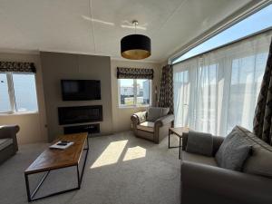 a living room with a couch and a table at Luxury Lodge Retreat with Hot Tub - Stewarts Resort 19 in St. Andrews