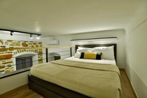 a bedroom with a large bed and a fireplace at Elements Syros Apartments in Ermoupoli