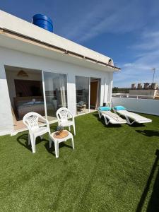 trawnik z krzesłami i łóżkiem oraz sypialnia w obiekcie Hotel Selva Arenal w El Arenal