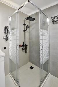 a shower with a glass door in a bathroom at Elements Syros Apartments in Ermoupoli +29 photos