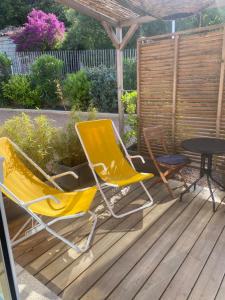 Dos sillas y una mesa en una terraza de madera. en Muratello Appart 1, en Porto Vecchio 8 fotos más