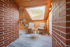 una stanza con due sedie e un muro di mattoni di Stubainest Schmidt Ferienwohnung a Fulpmes