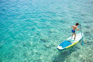 a man standing on a paddle board in the water at Villa Annouska in Halki