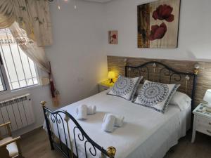 a bedroom with a bed with blue and white pillows at Cozy Bungalow with Private Terrace and Communal Pool in Torrevieja in Torrevieja +25 photos