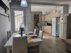 a kitchen with a table and a white refrigerator at Cozy Bungalow with Private Terrace and Communal Pool in Torrevieja in Torrevieja